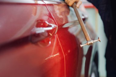 Servis istasyonunda araba gövdesine çizik atmadan araba tamircisinin kusurlarını temizlemesi