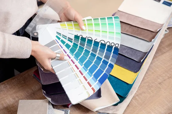 Decorador de interiorismo eligiendo color de pintura de pared para que coincida con elige telas para tapicería de muebles, cortinas en conjunto textil para apartamento — Foto de Stock