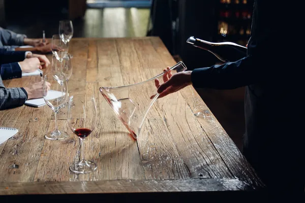 Sommelier倒入红葡萄酒到Carafe decanter，使曝气饮料。概念培训酒保和服务员 — 图库照片