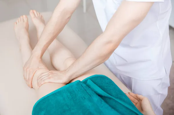 Therapist osteopathy working sports massage with knees legs of woman athlete — Stock Photo, Image
