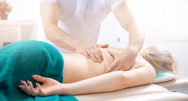 Clinic läkare Sport massage för ung kvinna idrottsman att återställa styrka och energi efter träning — Stockfoto
