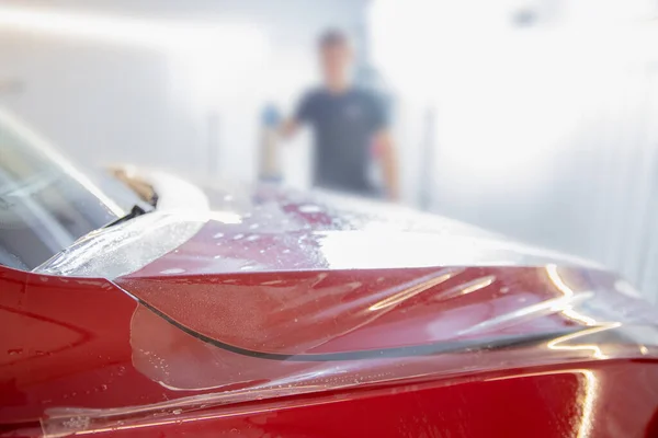 Concetto di protezione della vernice PPF è l'installazione di film in poliuretano sul cofano auto di lusso moderna — Foto Stock