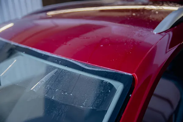 Master man instala tira de película de vinilo en zona de riesgo de parabrisas para proteger la pintura de la carrocería del coche de arañazos y virutas — Foto de Stock