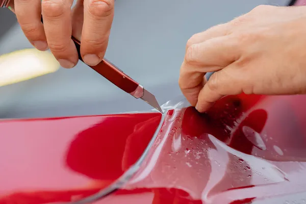 Maestro hombre instala película de vinilo proteger arcos de puertas coche cuerpo pintura — Foto de Stock