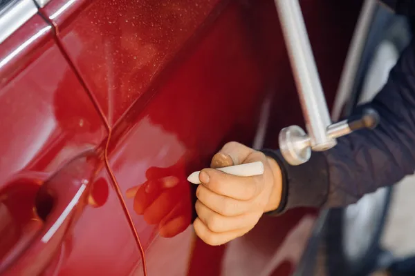 Servis istasyonunda araba gövdesine çizik atmadan araba tamircisinin kusurlarını temizlemesi — Stok fotoğraf
