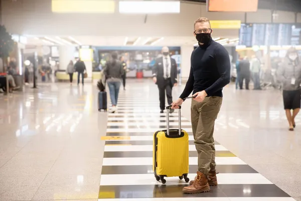 Concepto de nuevo viaje normal en avión. Viajero joven está usando máscara protectora en el aeropuerto después de pandemia covid, distanciamiento social — Foto de Stock