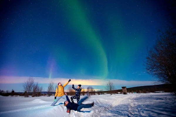 Sällskap vänner turist ser norrsken natt i skogen, mjuk fokus — Stockfoto