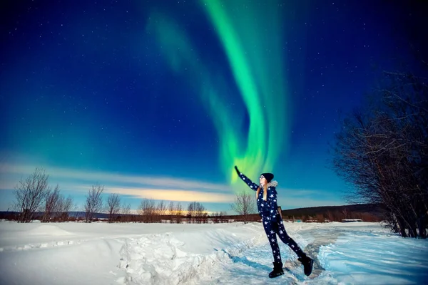 Kadın turist Aurora kuzey ışıklarına bakıyor. Ormanda gece, yumuşak odaklı. — Stok fotoğraf