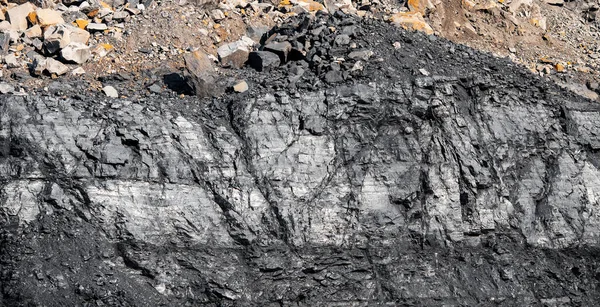 Geologischer Abschnitt des Bodens, Schichten aus Kohle und Gestein. Der Tagebau ist überlastet. Dunkle Textur schwarze Farbe — Stockfoto