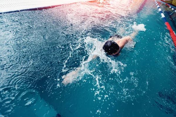 Profesionální plavec mladý muž v černé čepici v bazénu modrý bater na závodní trénink — Stock fotografie