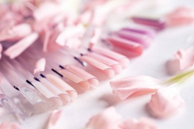 Bahar pembesi manikür ve çiçeklerle jel cilası seçmek için sahte tırnak örneklerini ayarla