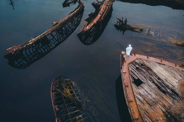 Turista se dívá na hřbitov starých dřevěných lodí Teriberka, Murmansk region, Rusko. Letecký pohled shora — Stock fotografie