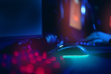 Bilgisayar oyuncusunun çalışma yeri bulanık arkaplan ile mavi neon ışığı