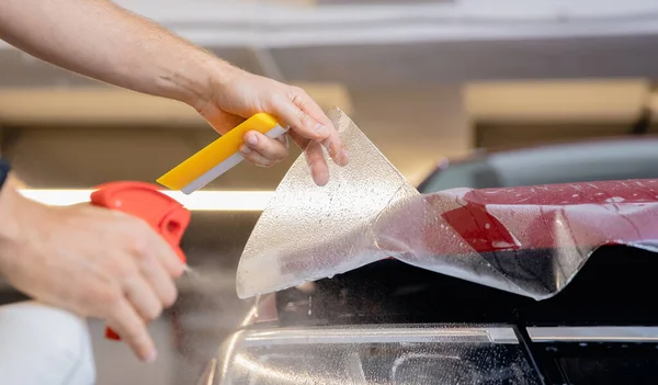 Concept of installing protective transparent vinyl film to protect paint and varnish of car — Stock Photo, Image