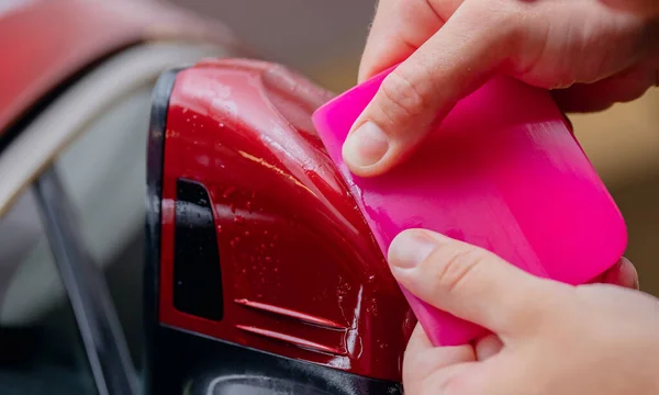 Detailní záběr Nainstaluje vinylové fólie pro ochranu karoserie bočních zrcátek červené auto — Stock fotografie