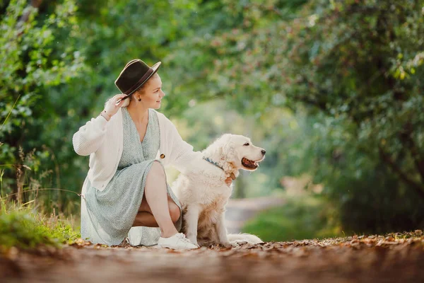 Jovem com Active, sorriso feliz golden retriever ao ar livre no parque de grama no dia ensolarado de verão — Fotografia de Stock