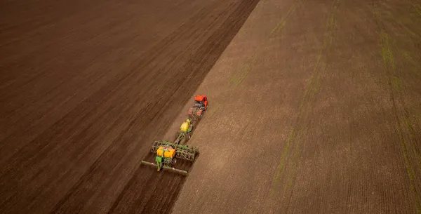 Farmář na traktoru obdělává a orá ornou půdu pro pěstování obilovin. Letecký pohled shora Zemědělský koncept — Stock fotografie