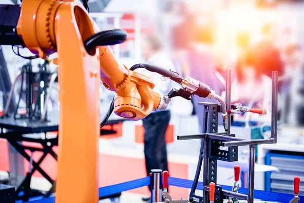 Closeup Yellow robot mão executa trabalho de soldagem em estruturas metálicas fábrica automática industrial, fundo leve — Fotografia de Stock