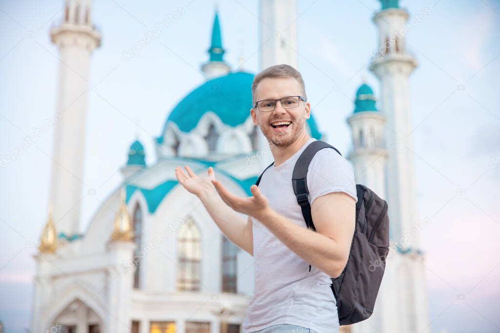 Happy tourist man with backpack smiling on background of Kul Sharif Mosque Kazan Kremlin. Concept Travel Russia