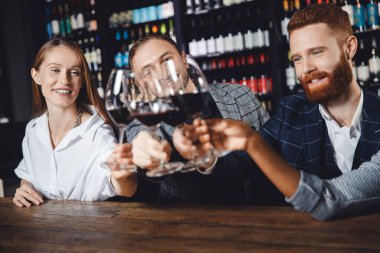 Parti restoranında kırmızı şarap içen mutlu çok kültürlü insanlar.