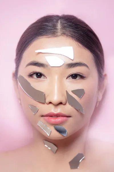 Indah Brunette perempuan asia potret mode dengan makeup palsu bulu mata pecahan cermin rusak di wajahnya — Stok Foto