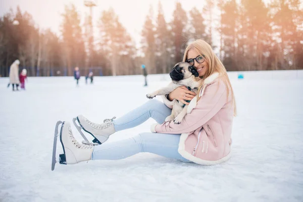 Gelukkige vrienden dieren, jonge vrouw gaat in voor sport op schaatsen met pug hond — Stockfoto