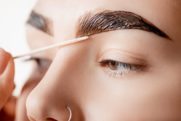 Correction and tint henna of eyebrows, master applies brush to woman marking on brow — Stock Photo, Image