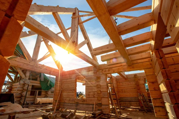 Nova casa madeira log construção interior com telhado de enquadramento exposto com luz solar — Fotografia de Stock