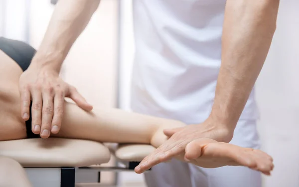Doctor performs sports massage arm hand therapy for young woman athlete after workout — Stock Photo, Image