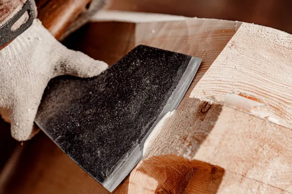 Carpintero de primer plano con hacha que trabaja con madera de tronco. Trabajos de carpintería, construcción de casas —  Fotos de Stock