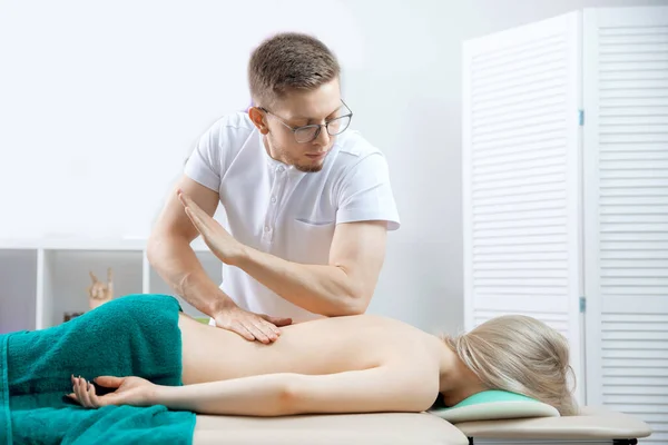 Doctor osteopath use therapy for woman in clinic. Concept physiotherapy massage for rehab sport injury athlete back — Stock Photo, Image