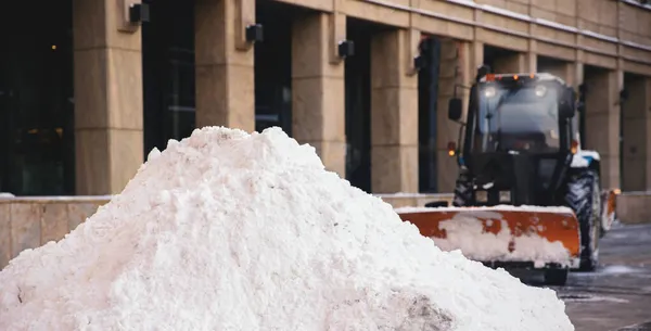 Escavatore servizio città pulizia neve inverno trattore dopo la tempesta di neve cortile luce del sole — Foto Stock