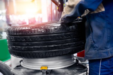 Garaj güneşinde otomatik makineye lastik takmak