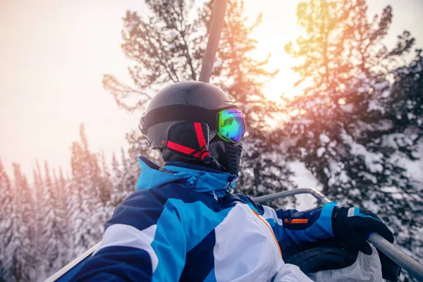 Konzept aktive Reise im Ort. Skifahrer mit Helm und Brille machen Selfie am Skilift — Stockfoto