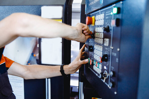 Industry Worker hand use tool and button for installation lathe machine on factory floor