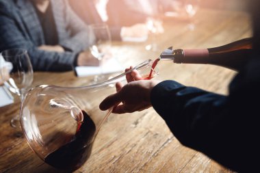 Sommelier ve barmen eğitimi, şişeden sürahiye kırmızı şarap döken adamın eli.