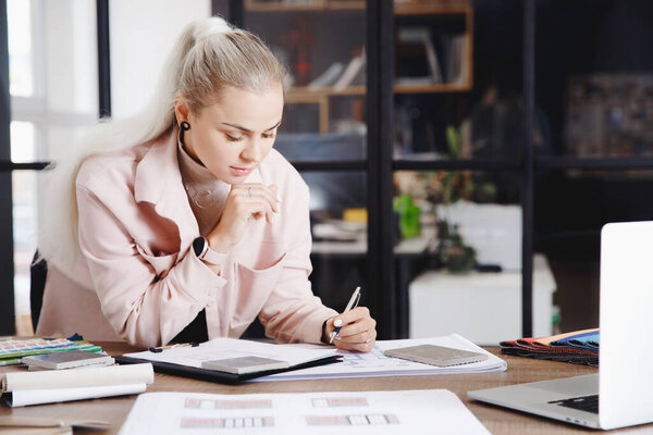 Woman professional architect and interior designer working in workplace, draw apartment plan on laptop
