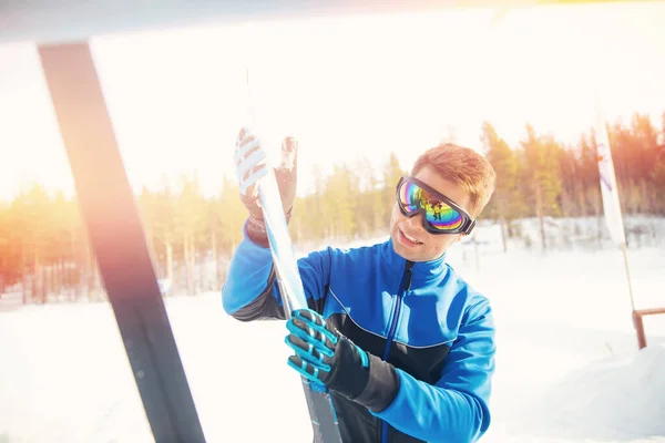 Чоловічий спортсмен готує лижі для тренувань на снігу, вибір мазі для ковзання при температурі повітря — стокове фото