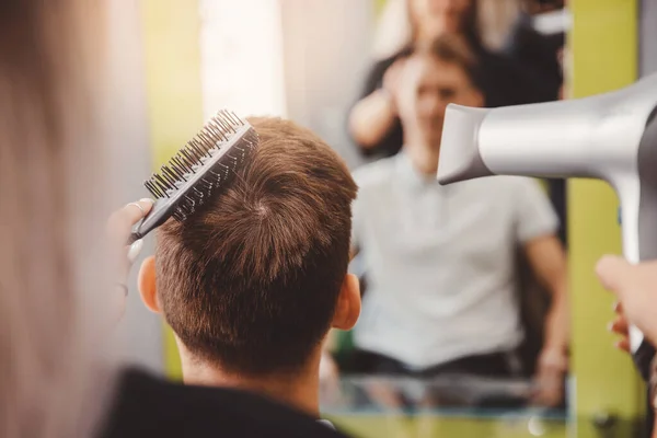 Master vrouw kapper doet kapsel en styling met droger haar naar guy kapper — Stockfoto