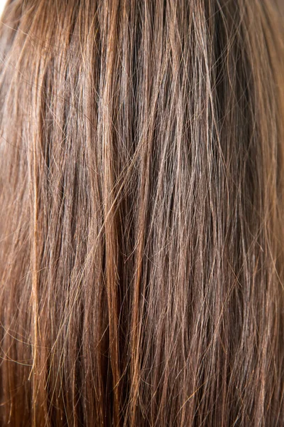 Текстура поврежденных женских волос крупным планом на сером фоне. потеря цвета и белка — стоковое фото