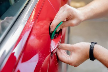 Kırmızı arabanın altındaki tehlikeli bölgede yakın çekim ana kurulumu başlatıldı. Boya koruması vinil filmdir.