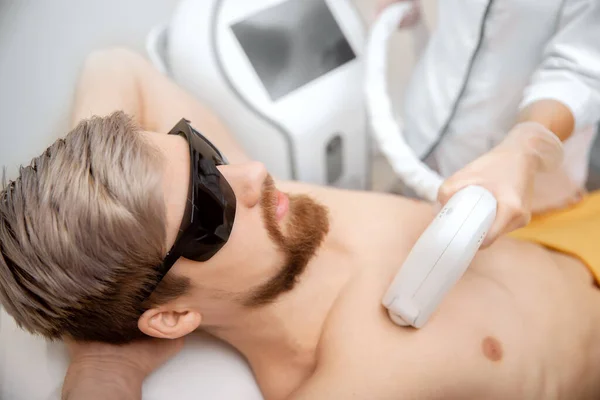 Donna operaia salone di bellezza dando uomo torso depilazione laser epilation studio — Foto Stock