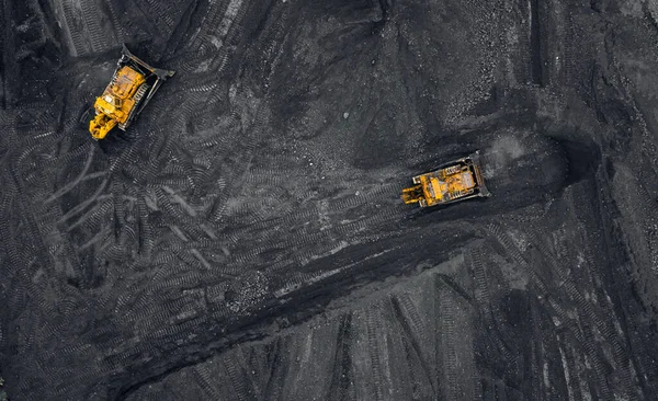 Lasting av kull, to gule gravemaskiner som håndterer antrasitt i en åpen gruve, utsyn over luften – stockfoto