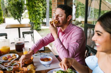 Latin Amerika 'da bir restoranın terasında Meksika yemeği yiyen genç bir Latin.