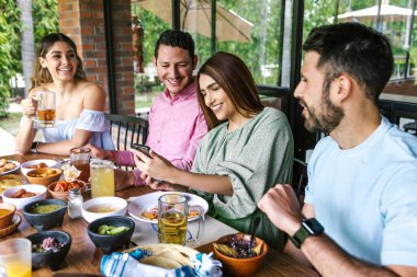 Latin Amerika 'da bir restoran terasında Meksika yemeği yiyen bir grup Latin arkadaş.