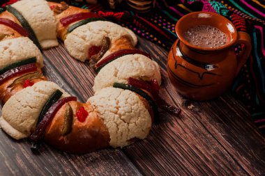 Rosca de Reyes ya da Epiphany keki ve Meksika Latin Amerika 'da tahta bir masada Meksika sıcak çikolatası.
