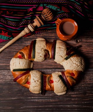 Rosca de Reyes ya da Epiphany keki ve Meksika Latin Amerika 'da tahta bir masada Meksika sıcak çikolatası.