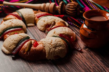 Rosca de Reyes ya da Epiphany keki ve Meksika Latin Amerika 'da tahta bir masada Meksika sıcak çikolatası.