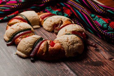 Rosca de Reyes veya Epiphany keki Meksika Latin Amerika 'da ahşap bir masada.