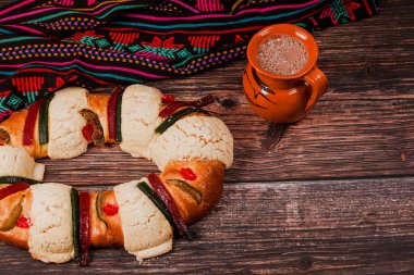 Rosca de Reyes ya da Epiphany keki ve Meksika Latin Amerika 'da tahta bir masada Meksika sıcak çikolatası.